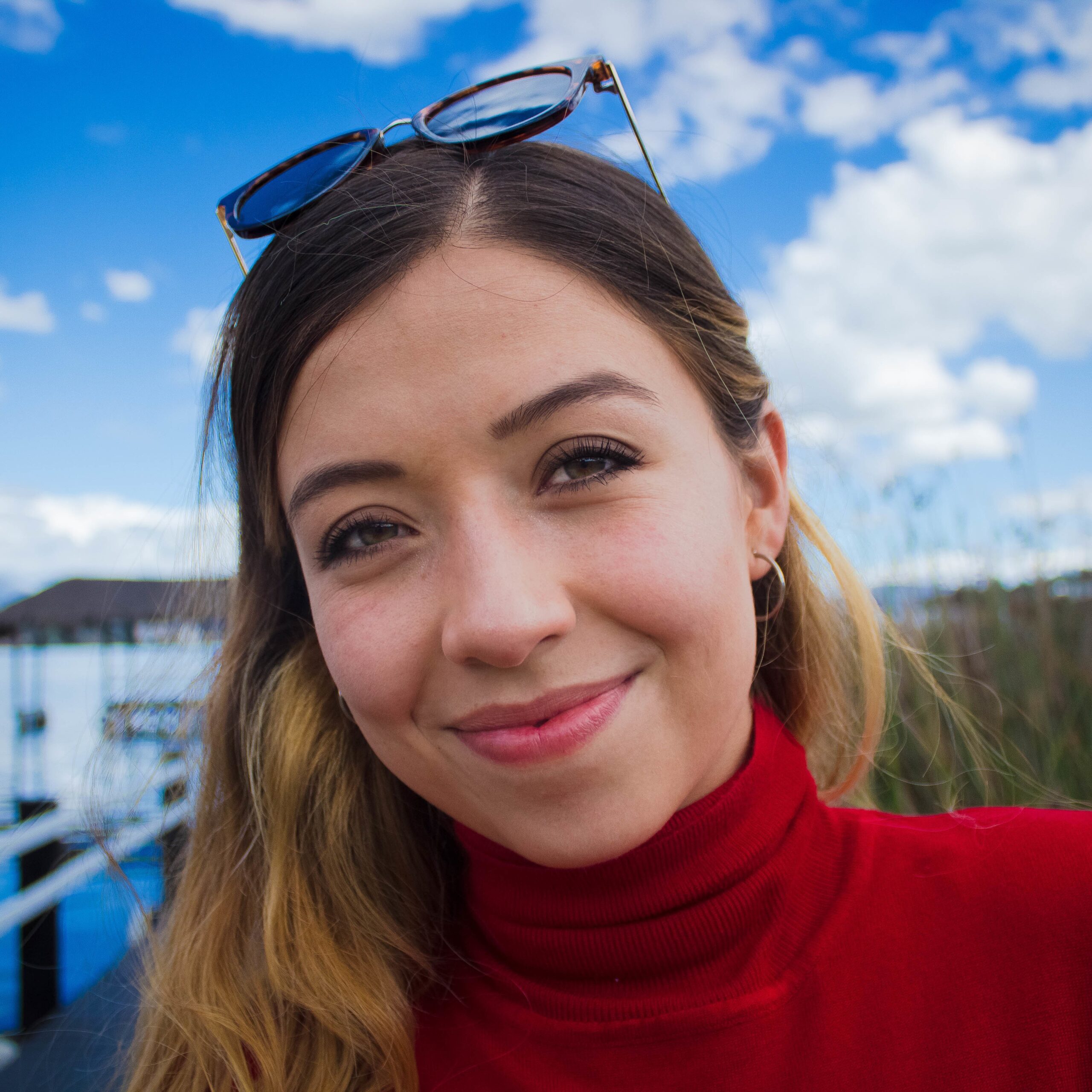 A portrait of a smiling young female standing near the sea - happiness concept